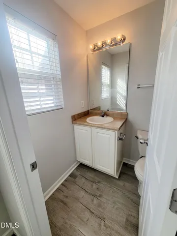 a white toilet sitting next to a bathroom sink and vanity