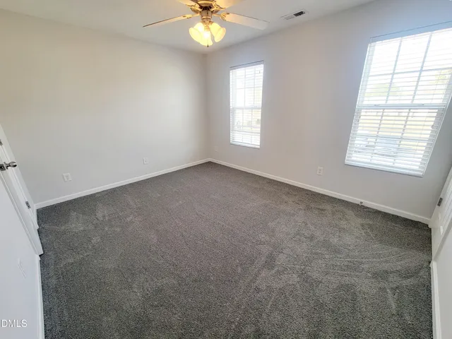 an empty room with a chandelier fan