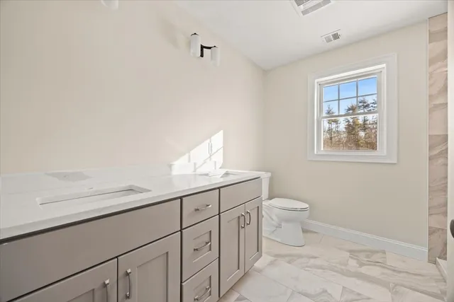 a bathroom with a toilet a sink and mirror