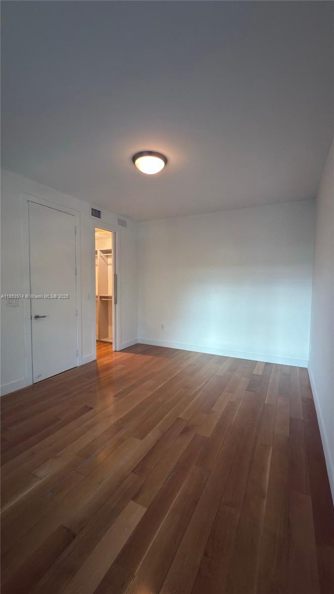 2021 Meridian Avenue, Unit 11 Miami Beach, FL 33139 - Photo 12 of 22 an empty room with wooden floor and windows