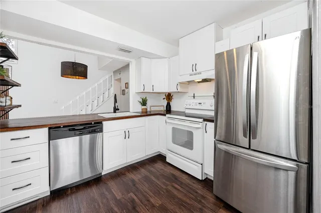 a kitchen with stainless steel appliances a refrigerator sink and cabinets
