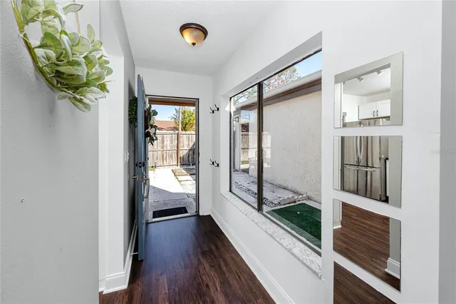 a view of a hallway with wooden floor and a living room