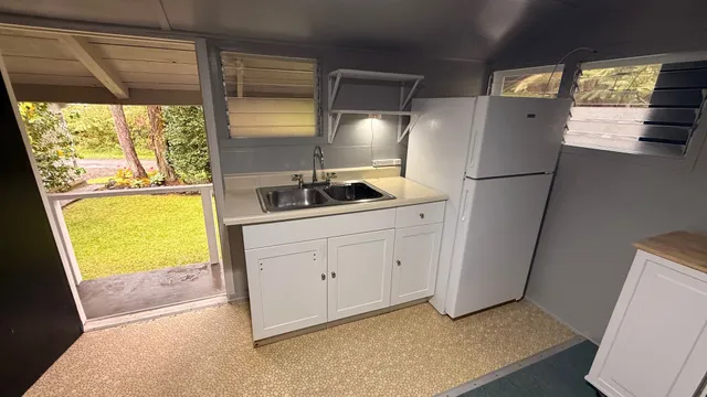 a view of room with refrigerator and wooden floor