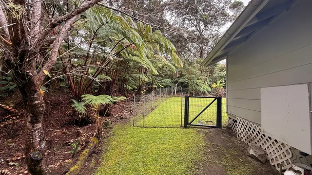 a view of a balcony with chairs and a small yard