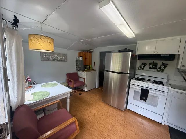 a kitchen with a refrigerator and a stove top oven