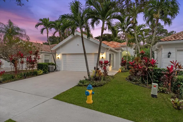 a front view of a house with a yard and potted plants