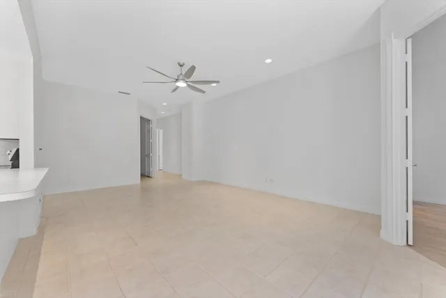 an empty room with a ceiling fan and a window