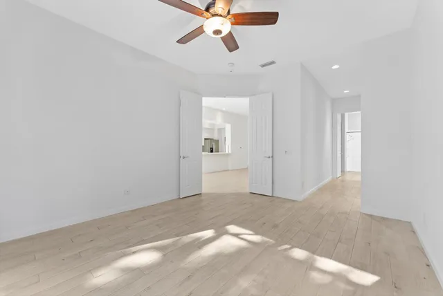 an empty room with wooden floor and windows