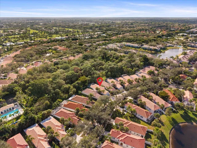 an aerial view of residential houses with outdoor space and trees