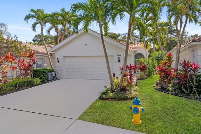 a front view of a house with a yard and fountain