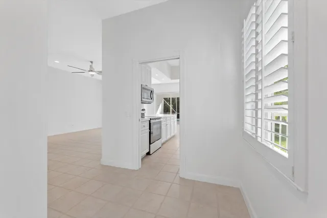 a view of a kitchen from the hallway with windows