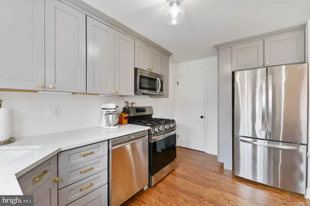 a kitchen with a refrigerator stove and white cabinets