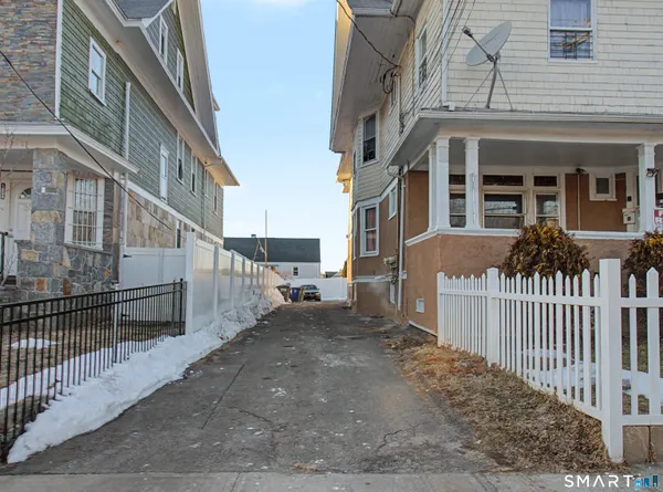 a view of a house with a small yard and wooden fence