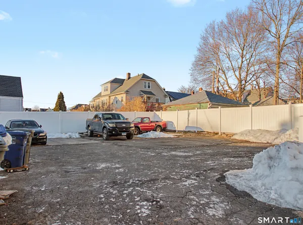 a view of a house with a yard and car parked