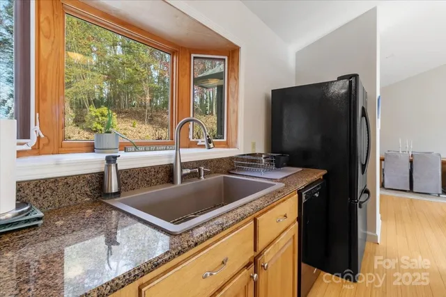 a kitchen with granite countertop sink stove and refrigerator