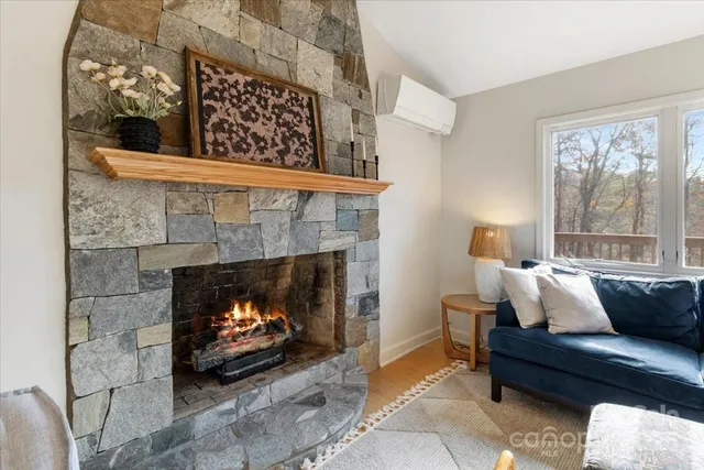 a living room with furniture a fireplace and a floor to ceiling window