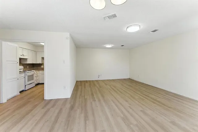 a view of empty room with wooden floor and stove
