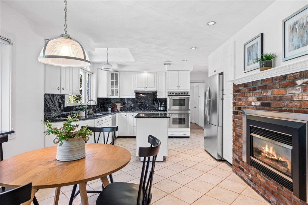 1 Fox Hunt Lane Winchester, MA 01890 - Photo 7 of 38 a kitchen with stainless steel appliances a dining table chairs stove refrigerator and cabinets
