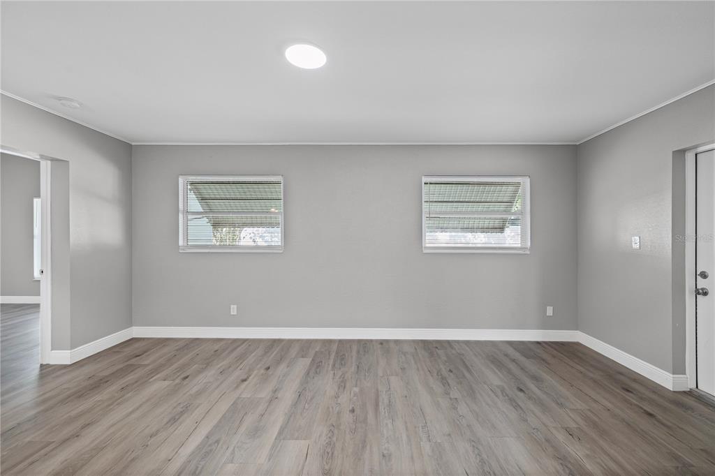 5046 99th Way North St. Petersburg, FL 33708 - Photo 12 of 41 an empty room with wooden floor and windows
