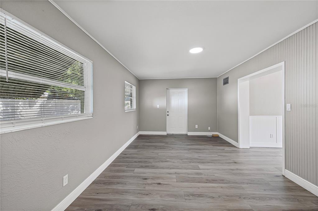 5046 99th Way North St. Petersburg, FL 33708 - Photo 13 of 41 a view of an empty room with wooden floor and a window