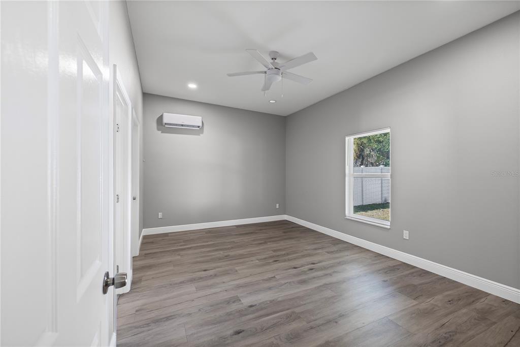 5046 99th Way North St. Petersburg, FL 33708 - Photo 15 of 41 an empty room with wooden floor and windows