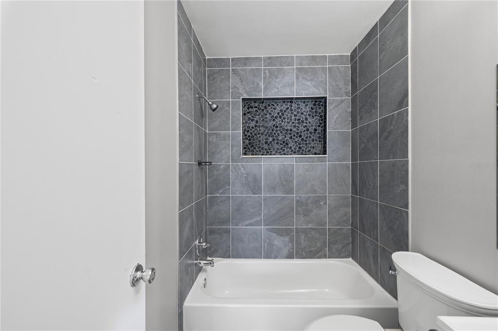 5046 99th Way North St. Petersburg, FL 33708 - Photo 23 of 41 a bathroom with a bathtub and a shower