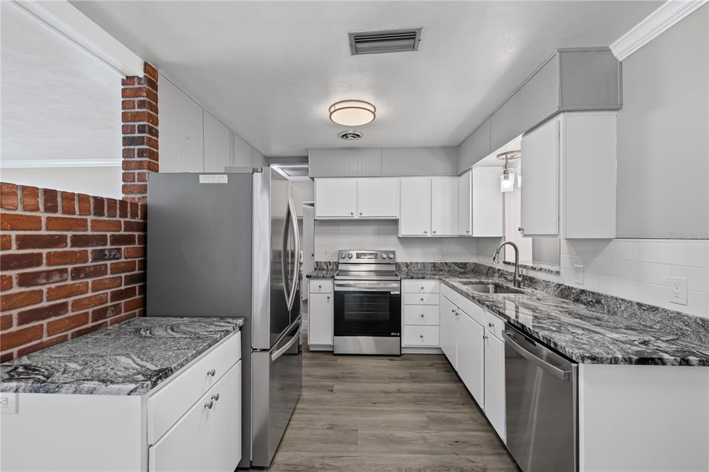 5046 99th Way North St. Petersburg, FL 33708 - Photo 8 of 41 a kitchen with a stove and a refrigerator