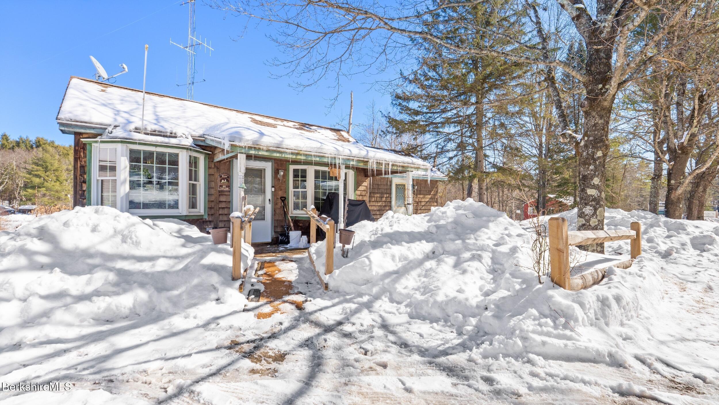 93 South Main Road Otis, MA 01253 - Photo 4 of 27 a view of a house with backyard outdoor seating and covered with snow in the background
