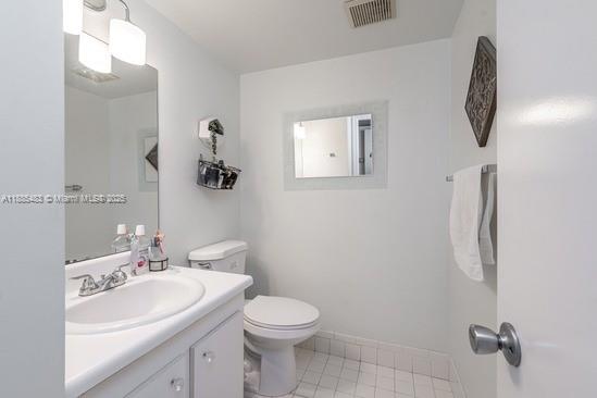 13255 Southwest 7th Court, Unit 403D Pembroke Pines, FL 33027 - Photo 12 of 19 a bathroom with a toilet sink and mirror