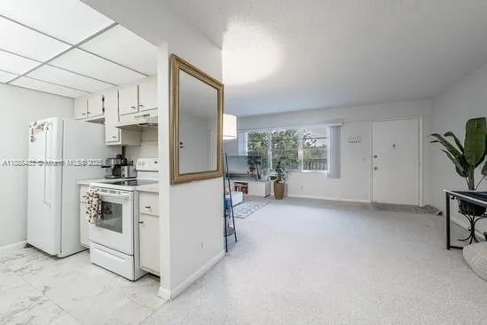 a kitchen with stainless steel appliances a refrigerator sink and white cabinets