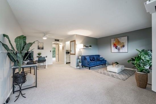 13255 Southwest 7th Court, Unit 403D Pembroke Pines, FL 33027 - Photo 8 of 19 a living room with furniture potted plant and a window