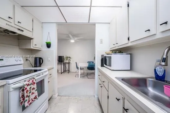 a kitchen with stainless steel appliances granite countertop a sink a stove and a microwave