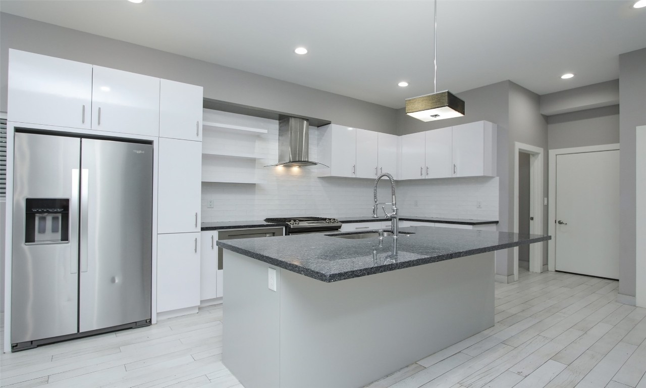 309 East 43rd Street, Unit A Houston, TX 77022 - Photo 12 of 35 a kitchen with stainless steel appliances granite countertop a refrigerator a sink and a stove
