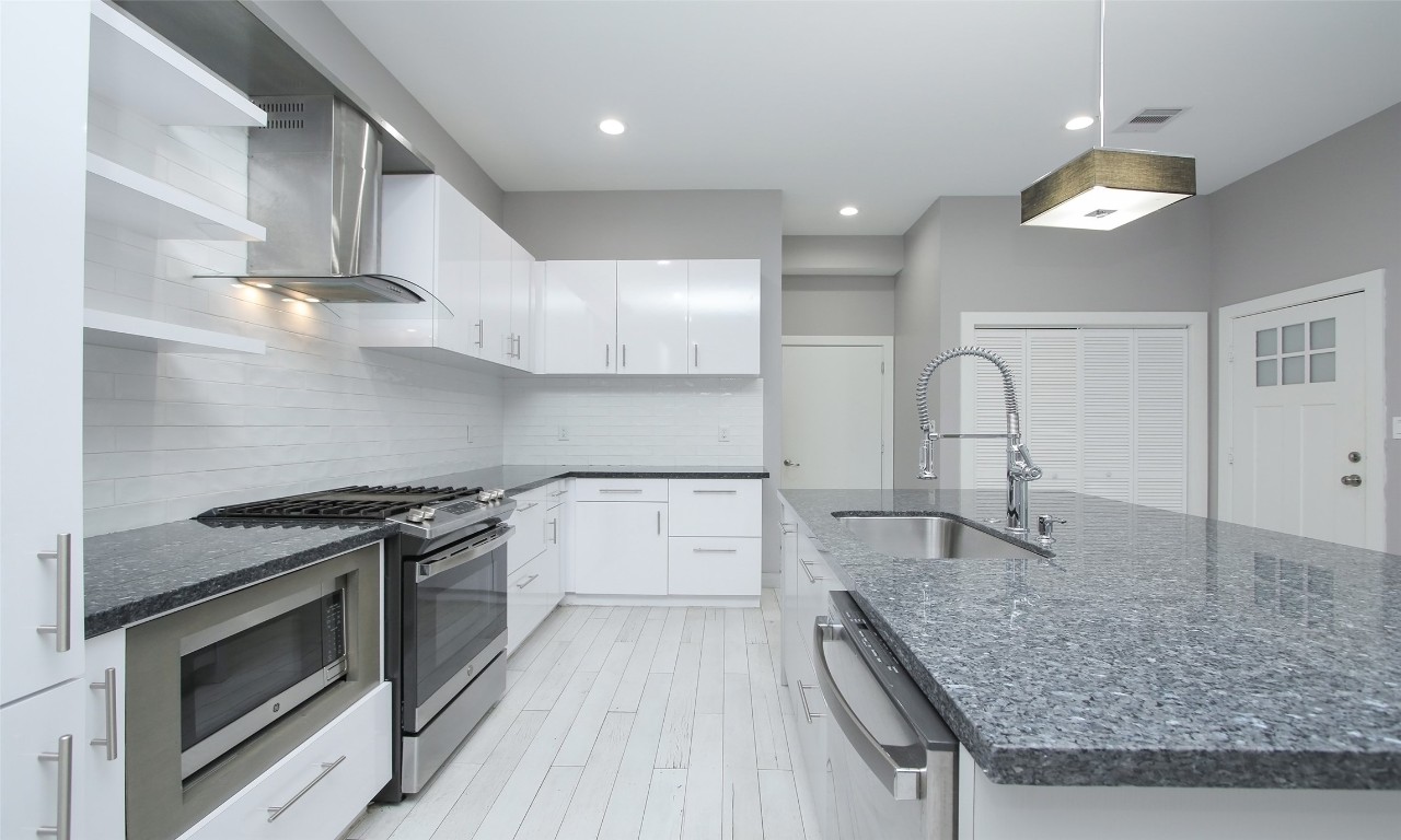 309 East 43rd Street, Unit A Houston, TX 77022 - Photo 14 of 35 a kitchen with granite countertop a sink stainless steel appliances and cabinets
