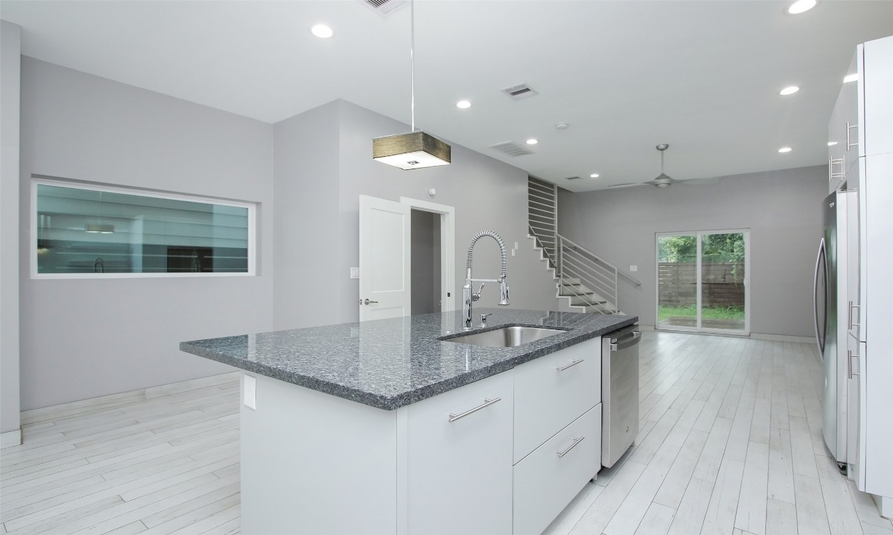 309 East 43rd Street, Unit A Houston, TX 77022 - Photo 15 of 35 a kitchen with stainless steel appliances granite countertop a sink counter space and wooden floors