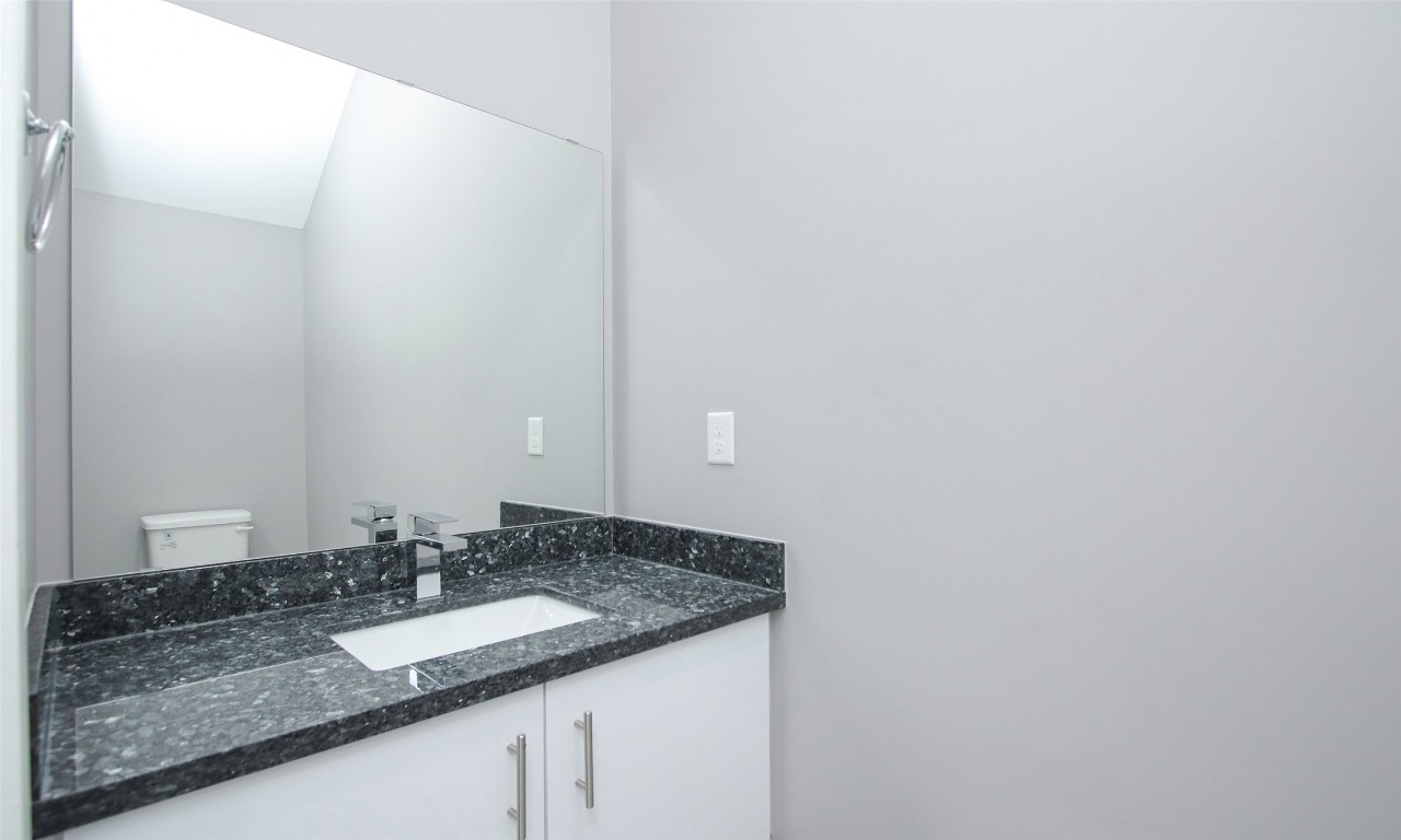 309 East 43rd Street, Unit A Houston, TX 77022 - Photo 18 of 35 a bathroom with a granite countertop sink and a mirror