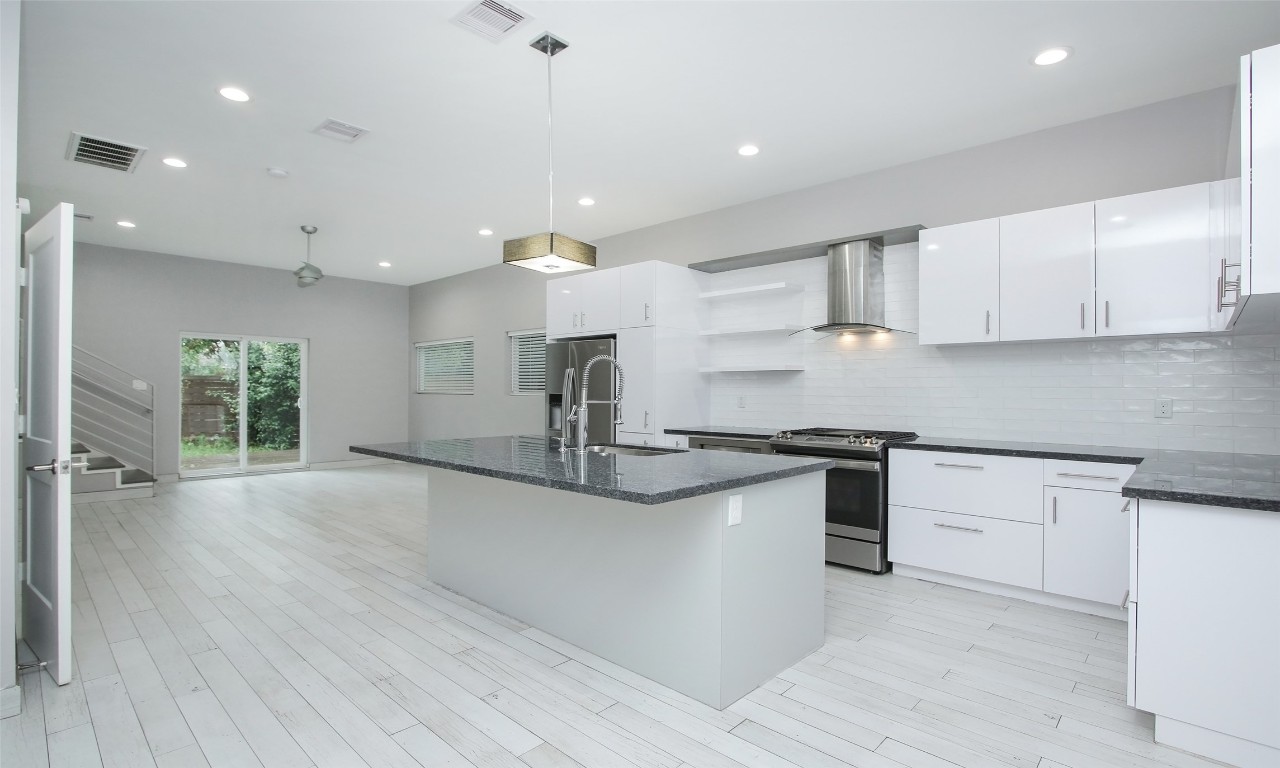 309 East 43rd Street, Unit A Houston, TX 77022 - Photo 2 of 35 a kitchen with stainless steel appliances granite countertop a sink and a stove top oven
