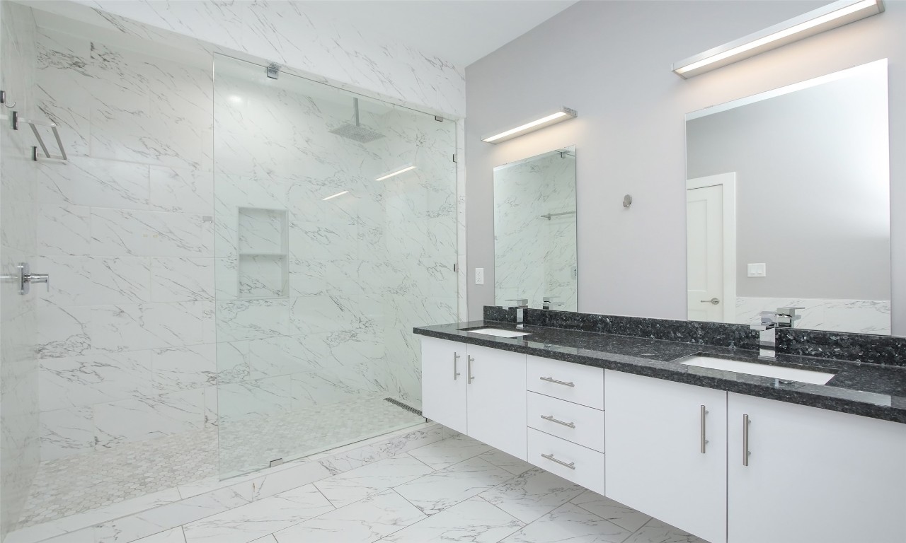 309 East 43rd Street, Unit A Houston, TX 77022 - Photo 23 of 35 a bathroom with a granite countertop sink a mirror and a shower