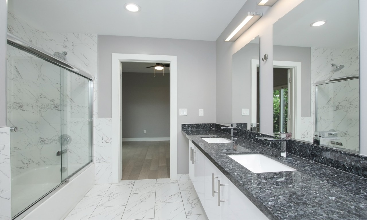 309 East 43rd Street, Unit A Houston, TX 77022 - Photo 27 of 35 a bathroom with a granite countertop sink mirror and shower