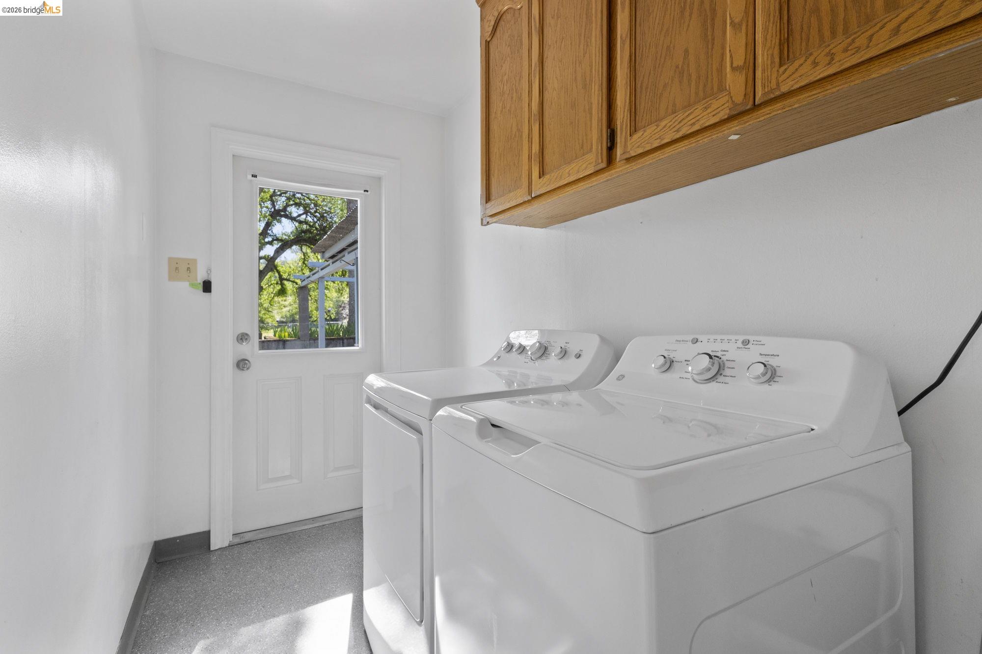 18363 Yosemite Road Tuolumne, CA 95379 - Photo 16 of 34 Bright utility space featuring white walls and a white paneled door with a clear glass panel