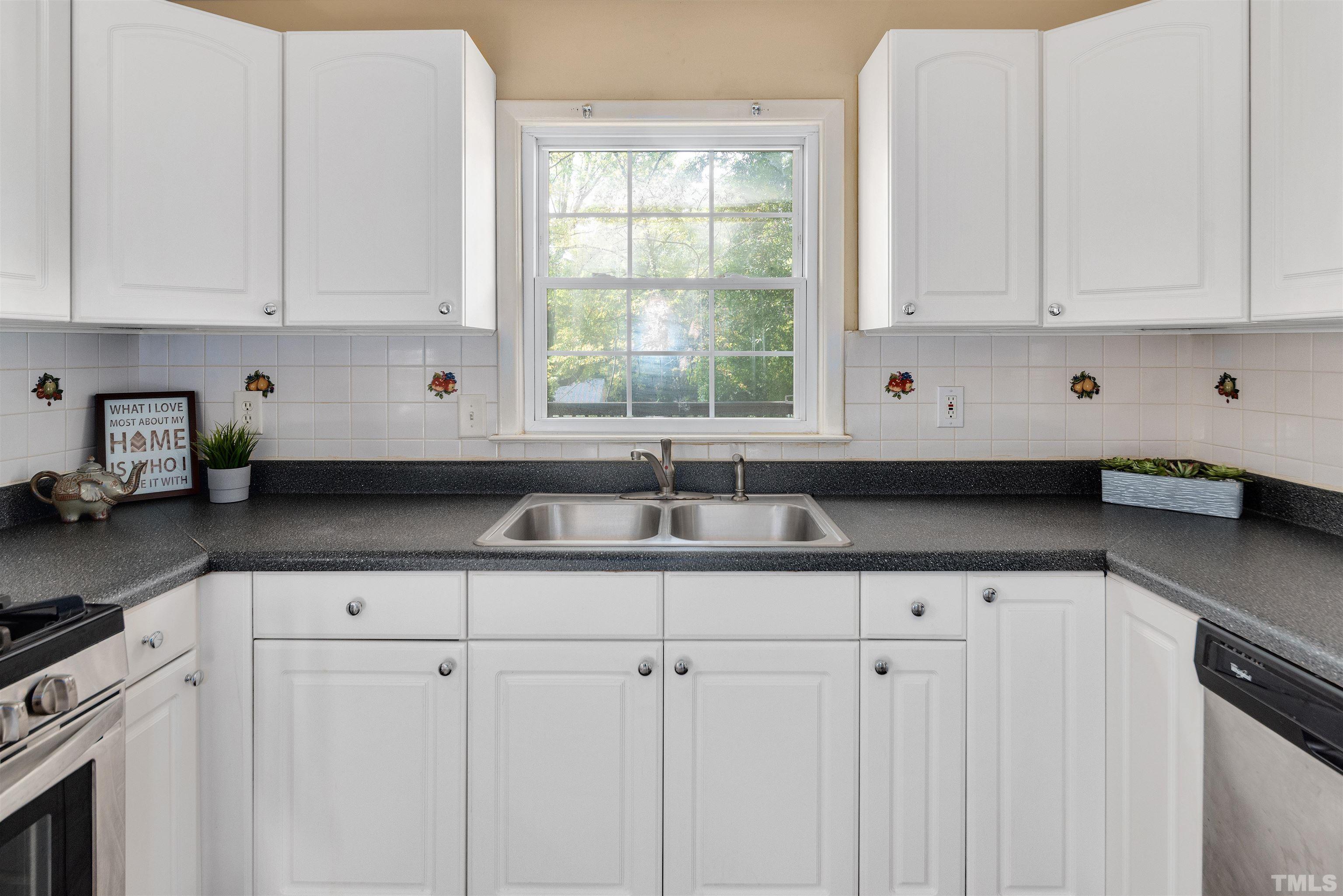 711 Latta Street Raleigh, NC 27607 - Photo 13 of 30 a kitchen with granite countertop white cabinets and sink