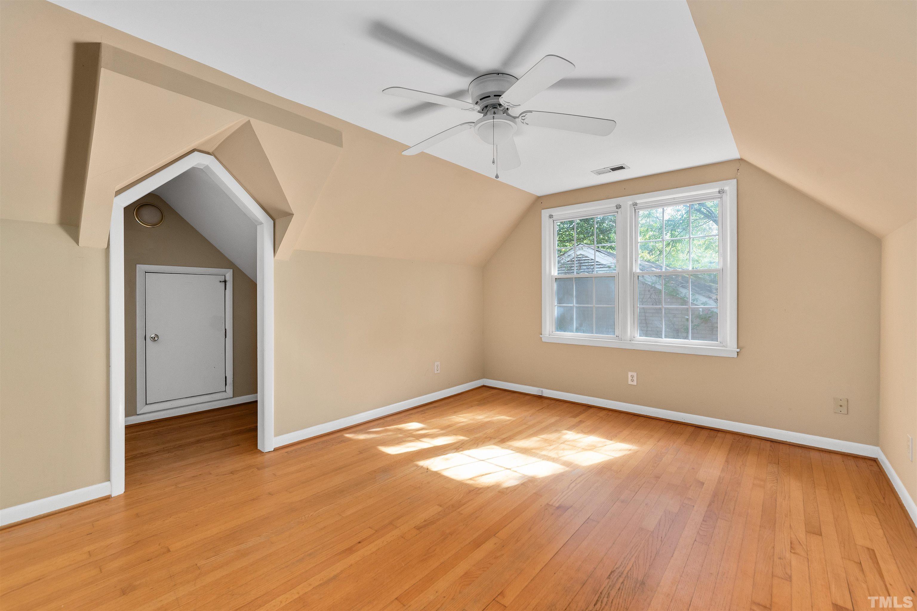 711 Latta Street Raleigh, NC 27607 - Photo 19 of 30 an empty room with wooden floor chandelier fan and windows