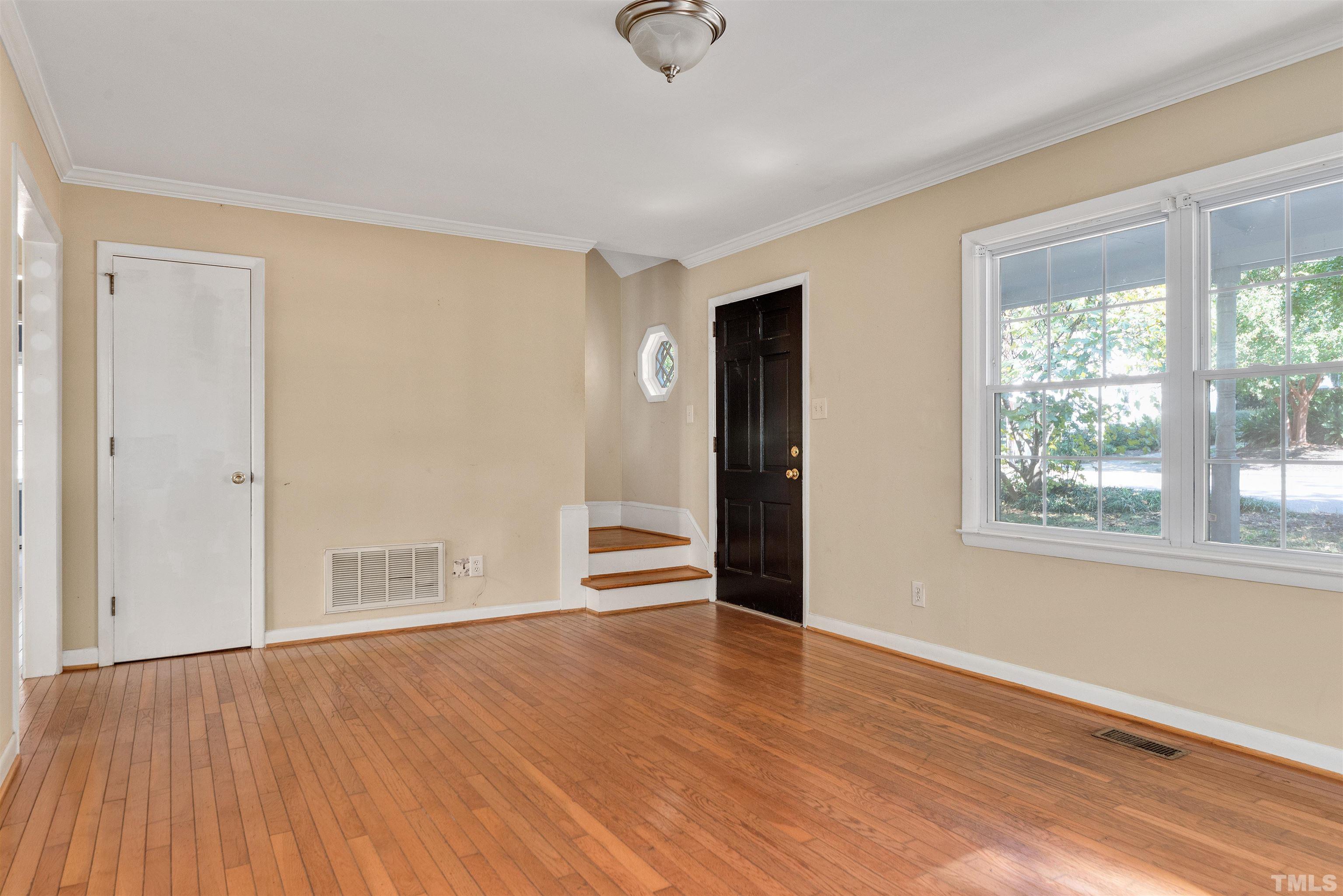711 Latta Street Raleigh, NC 27607 - Photo 5 of 30 an empty room with wooden floor and windows