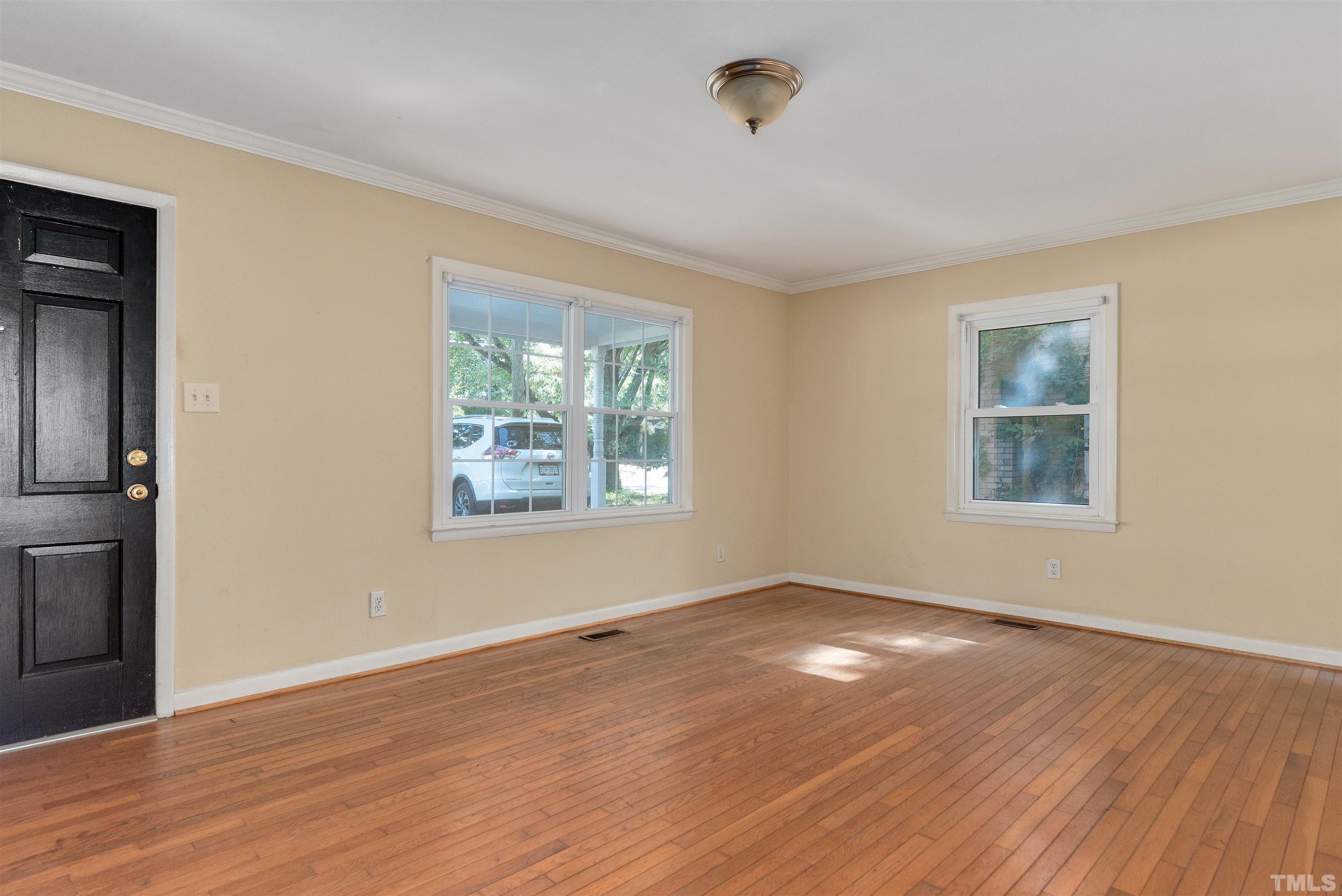 711 Latta Street Raleigh, NC 27607 - Photo 6 of 30 a view of an empty room with wooden floor and a window