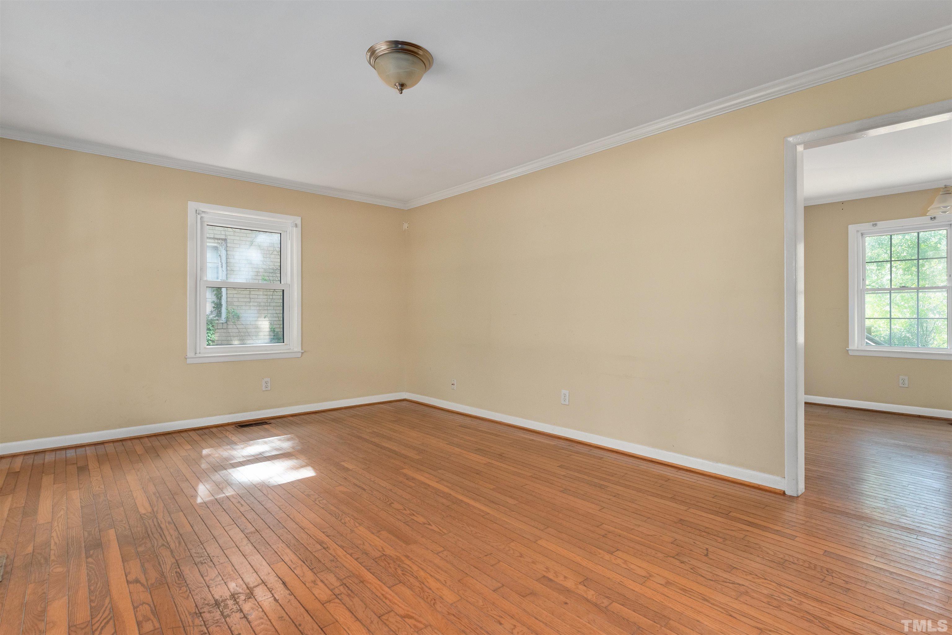 711 Latta Street Raleigh, NC 27607 - Photo 7 of 30 an empty room with wooden floor and windows