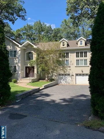 a front view of a house with a garden and yard