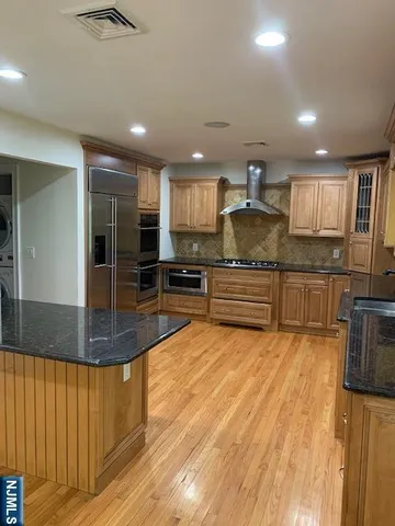 a large kitchen with stainless steel appliances granite countertop a stove and a sink