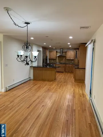 a kitchen with stainless steel appliances kitchen island granite countertop wooden floors and cabinets