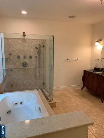 a bathroom with a tub a sink and a shower