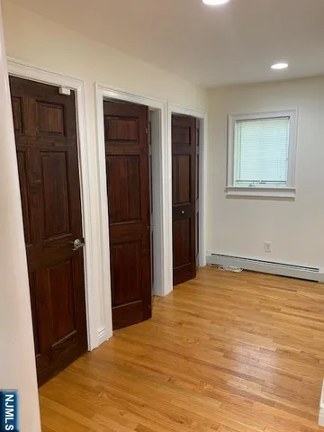 a view of an empty room with closet and wooden floor